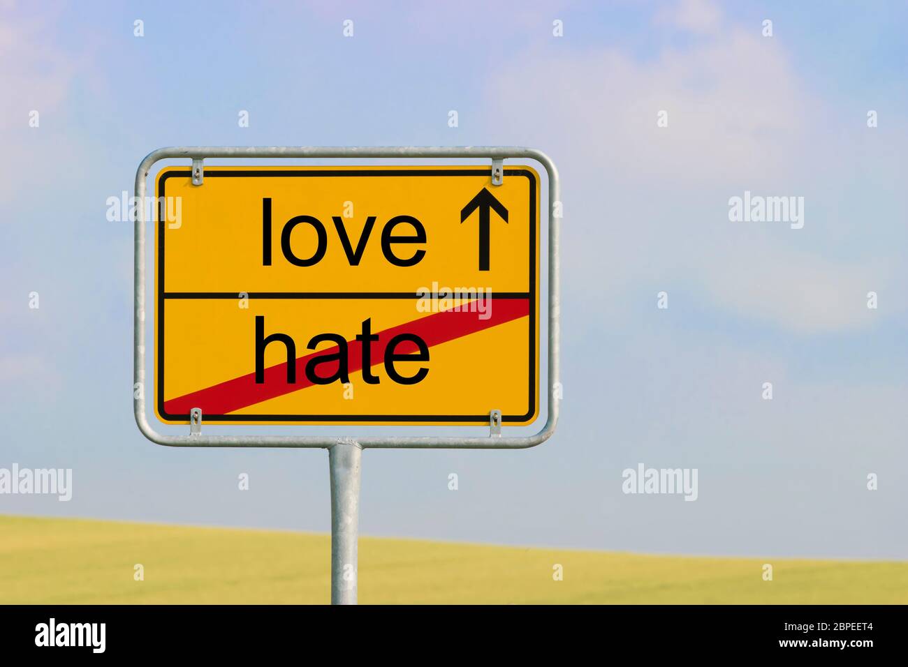 Yellow town sign with text 'hate love' Stock Photo