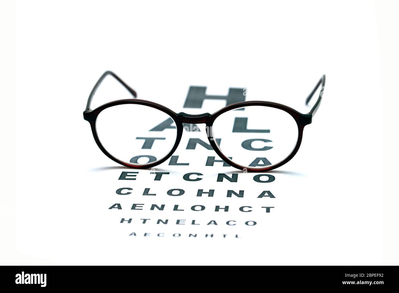 eyeglasses and eye test chart isolated over white background Stock