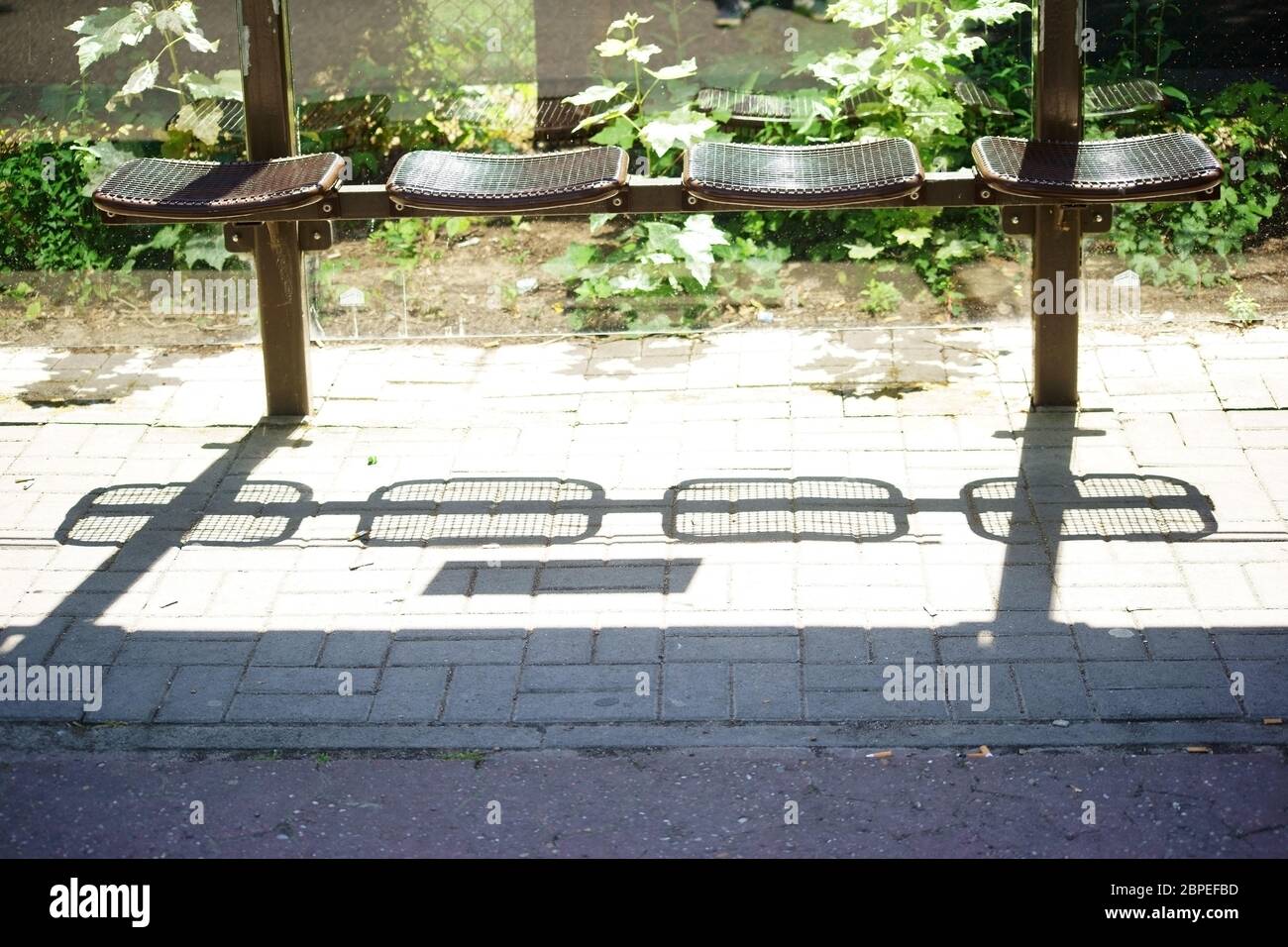 Die Sitze einer Bushaltestelle werfen abstrakte Schatten. Stock Photo