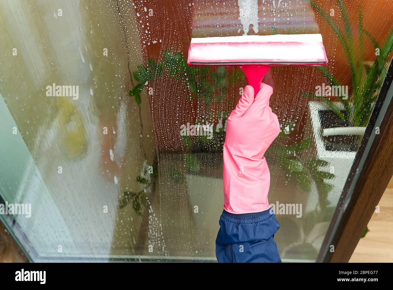 window cleaning. A woman in pink rubber gloves washes a window in a house.  Happy Woman In Gloves Cleaning Window. Concept for home cleaning services  Stock Photo - Alamy