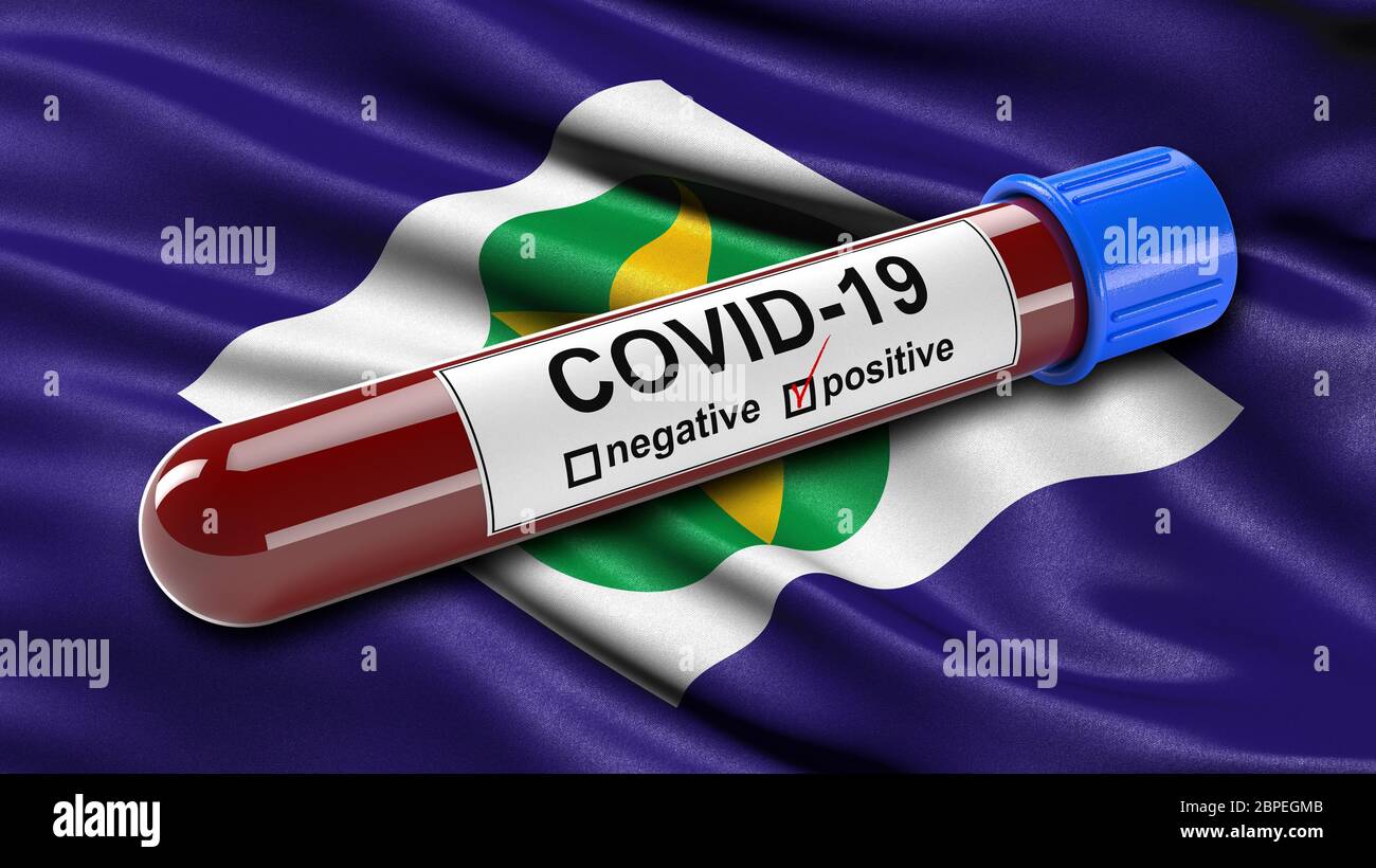 Brazilian state flag of Mato Grosso waving in the wind with a positive Covid-19 blood test tube. Stock Photo