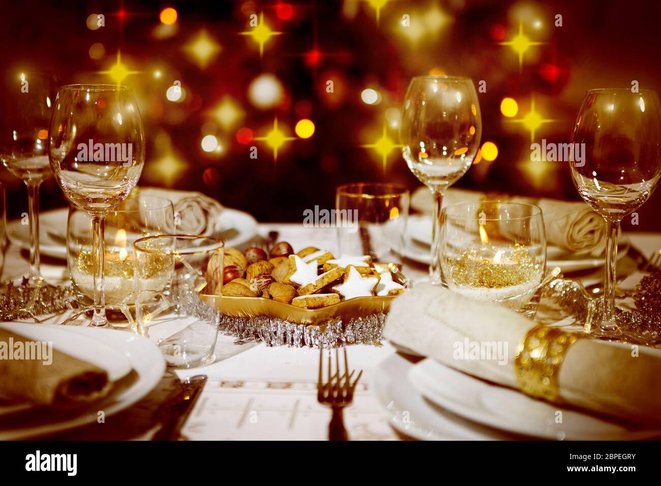 ein festlich gedeckter Tisch, im Hintergrund ein bunter Weihnachtsbaum Stock Photo