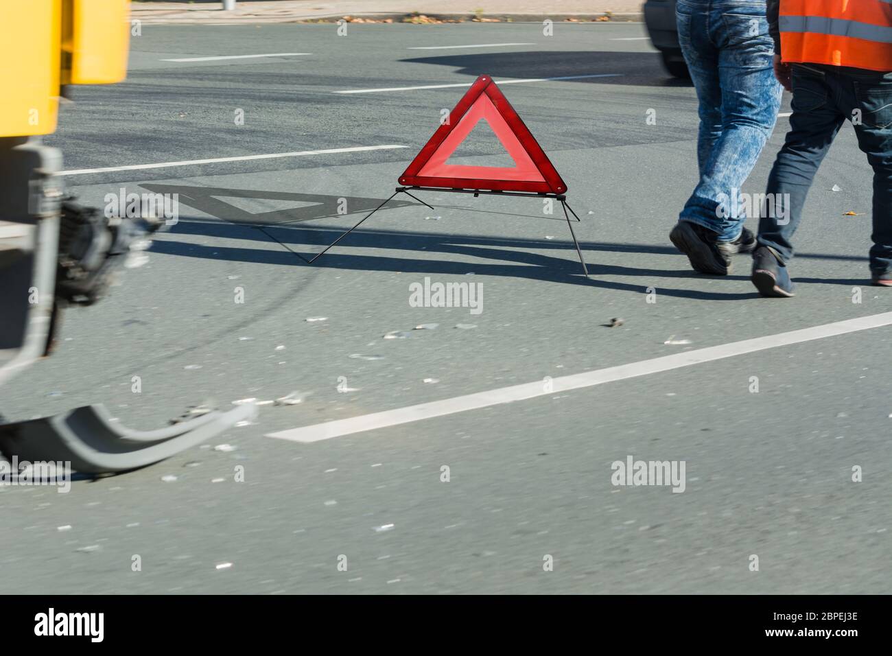 Autounfall, Unfall auf der Straße, beschädigte Autoteile und Warndreieck  nach dem Zusammenstoß in der Stadt. Stock Photo