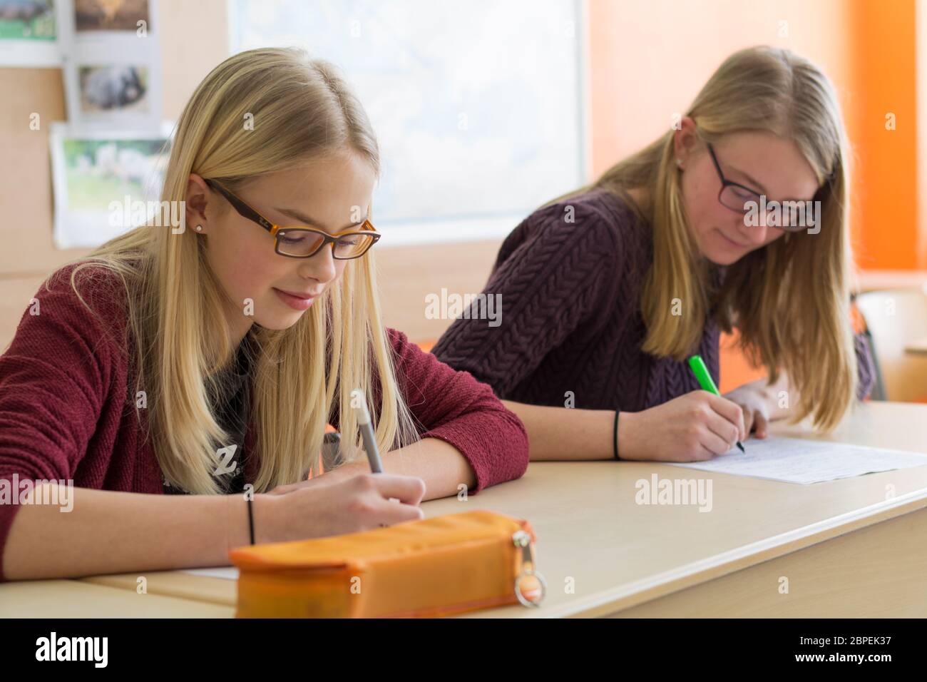 Zwei Mädchen schreiben im Klassenzimmer einen Test Stock Photo