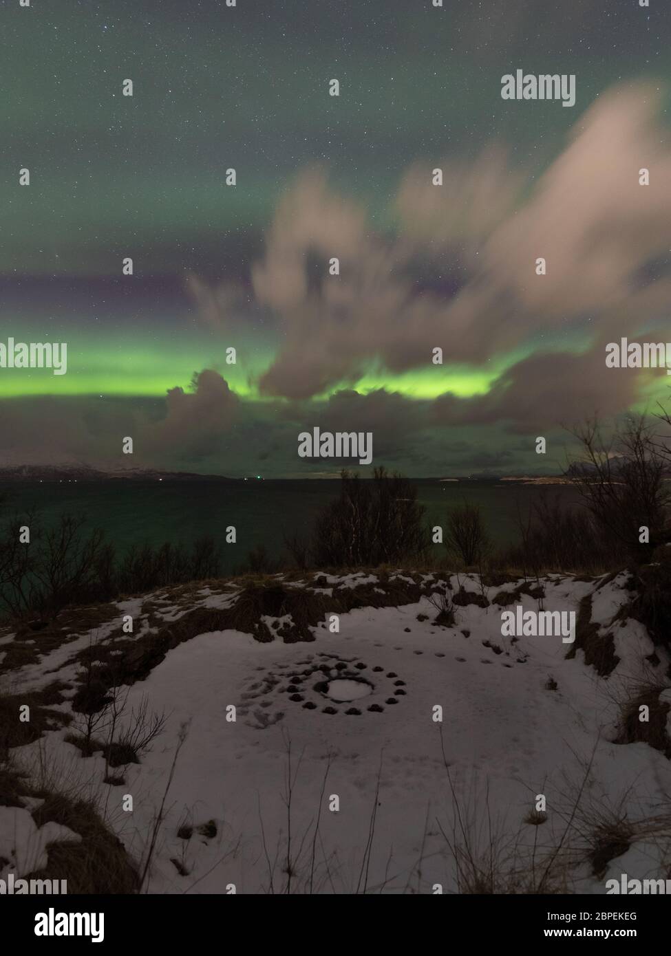 Aurora borealis over world war II reminder - Bremnes fort in Bodo, Norway.  Circe on snow marks gun emplacement. Cold night with green sky and fast mov  Stock Photo - Alamy