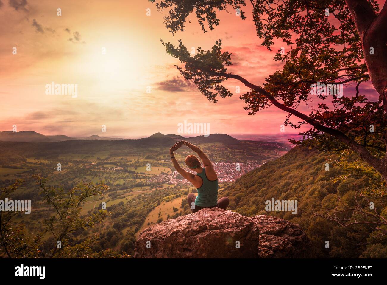 Junge Frau macht Yoga mit Ausicht auf die Schwäbische Alb Stock Photo