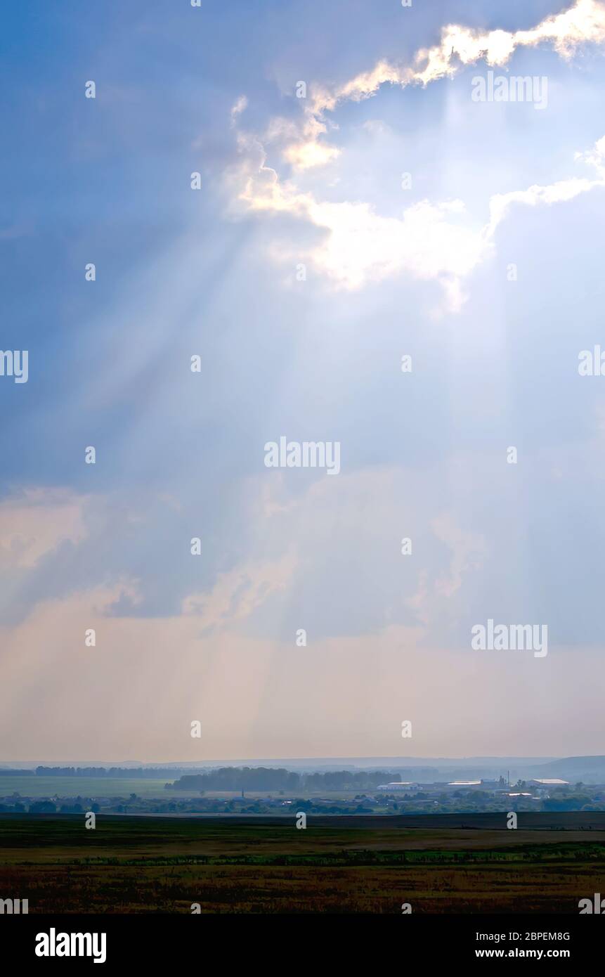 The rays of the evening sun falling through a gap in the cloud on the ...