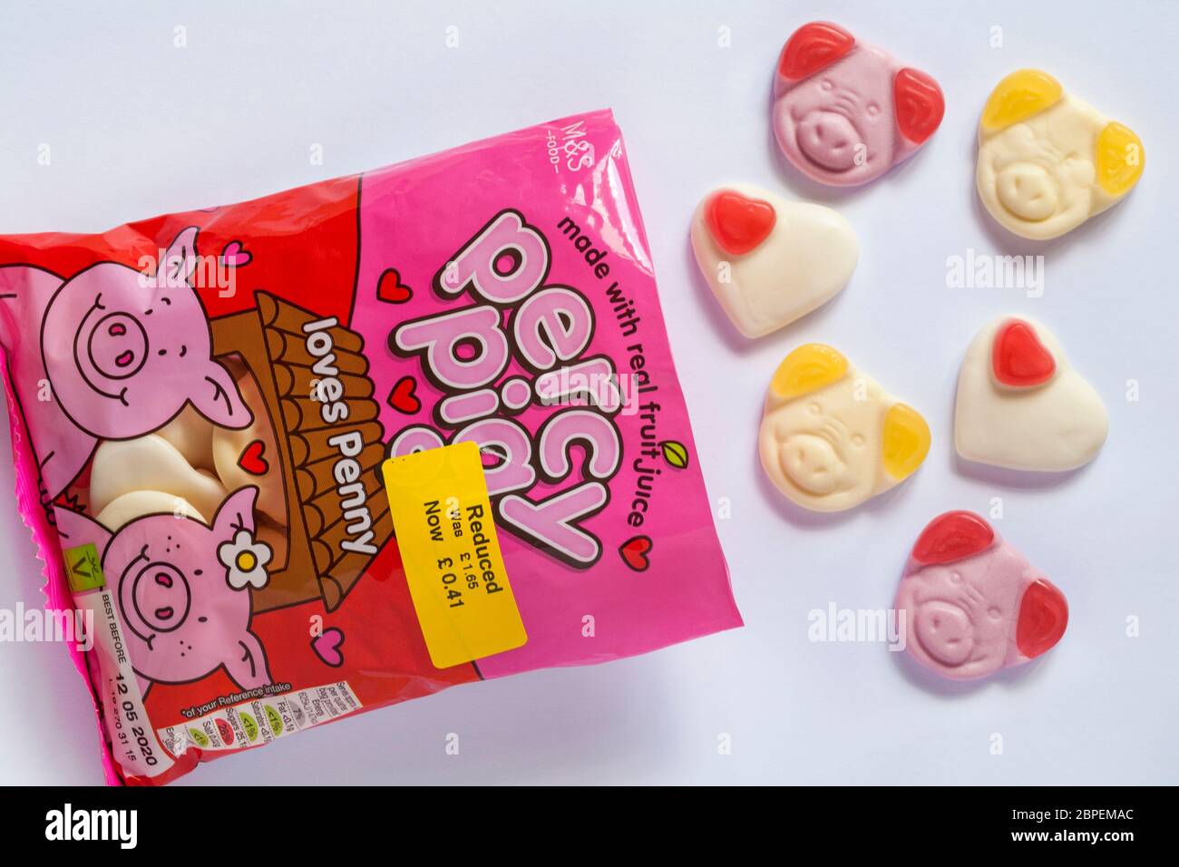 packet of percy pig loves Penny sweets made with real fruit juice opened to show contents set on white background - reduced food yellow sticker Stock Photo