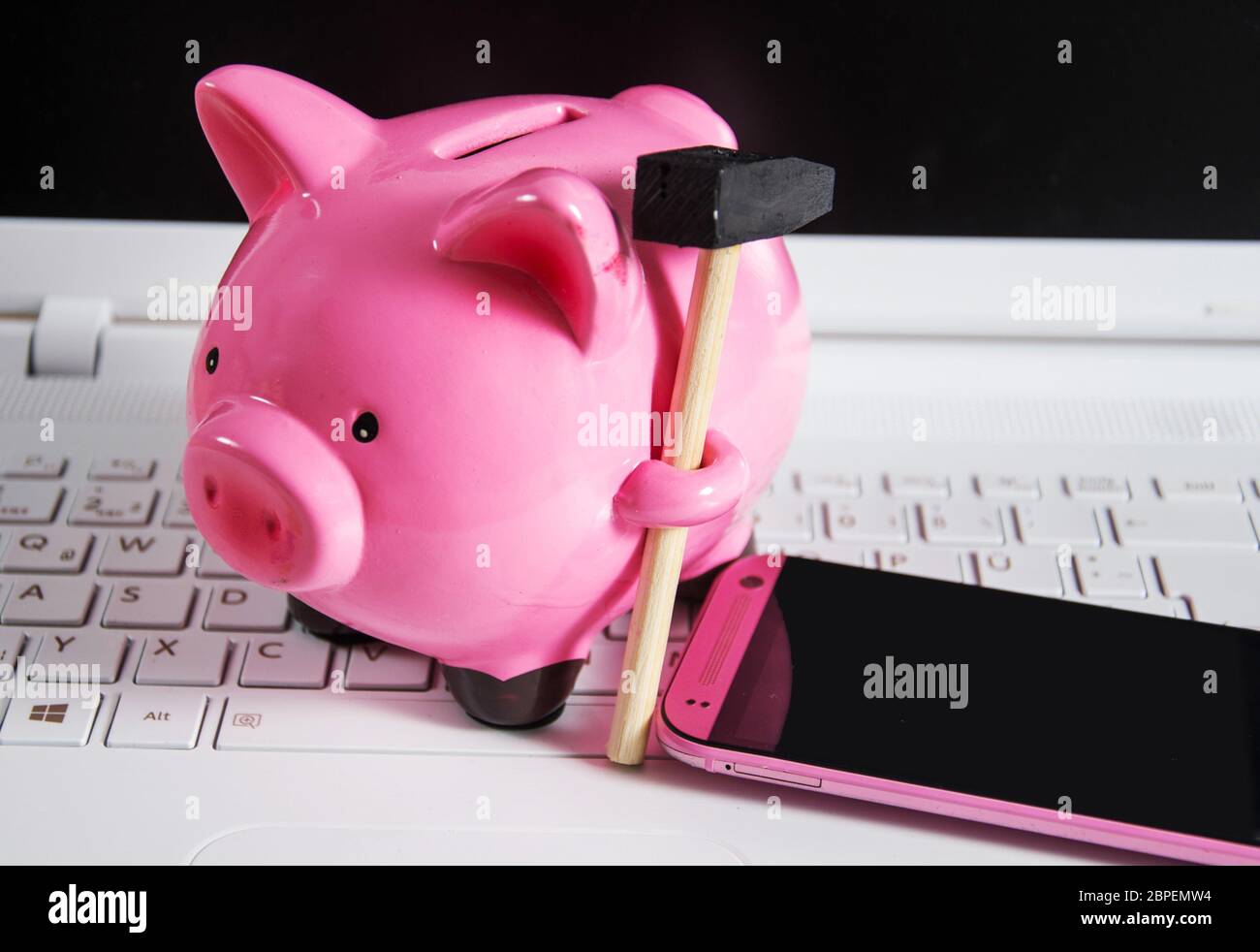 Sparschwein mit Handy auf einer Tastatur Stock Photo