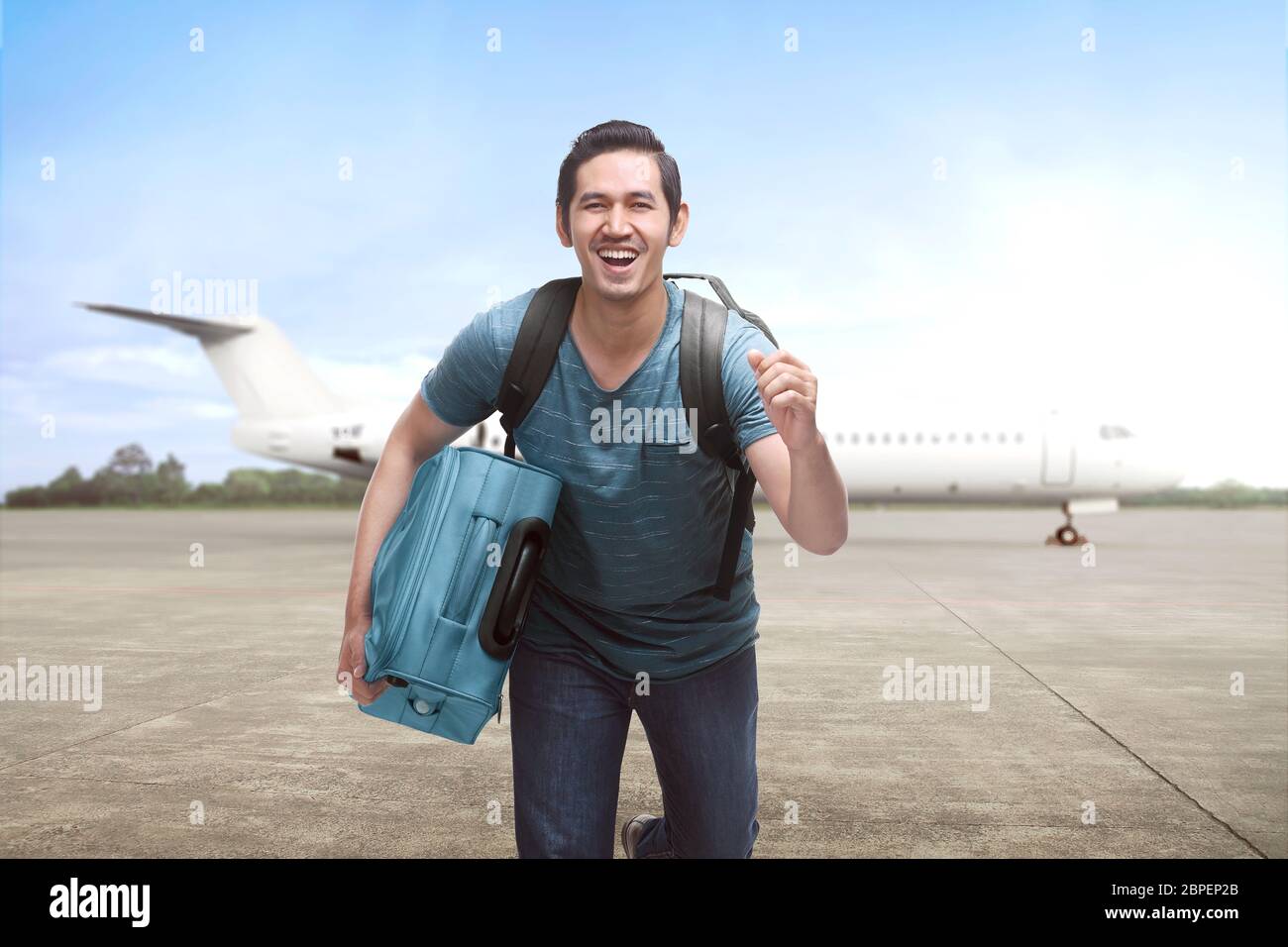 Young asian travelling man get off the plane with suitcase on the landing  strip Stock Photo - Alamy