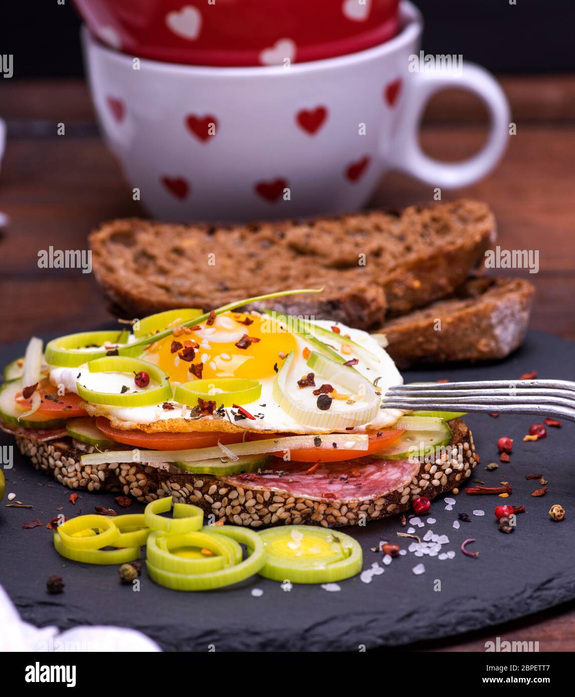 a sandwich made of rye bread, roasted egg, smoked sausage and ...