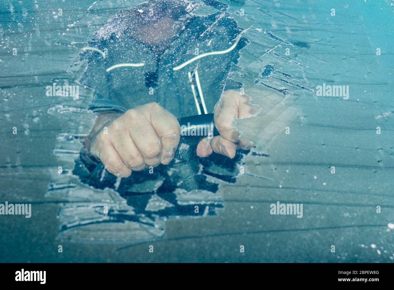 Mann am Steuer eines Fahrzeugs mit wenig Sicht durch gefrorene Windschutzscheibe Stock Photo
