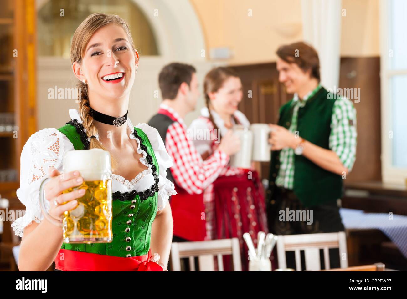 Young People In Traditional Bavarian Tracht In Restaurant Or Pub One young-people-in-traditional-bavarian-tracht-in-restaurant-or-pub-one