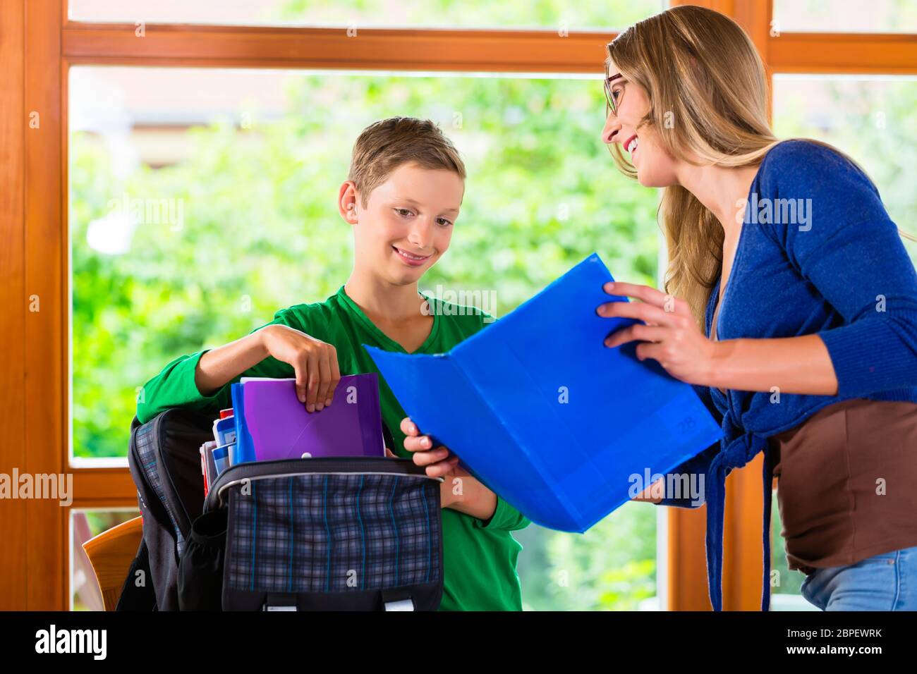 Mother and son packing school bag for next day Stock Photo