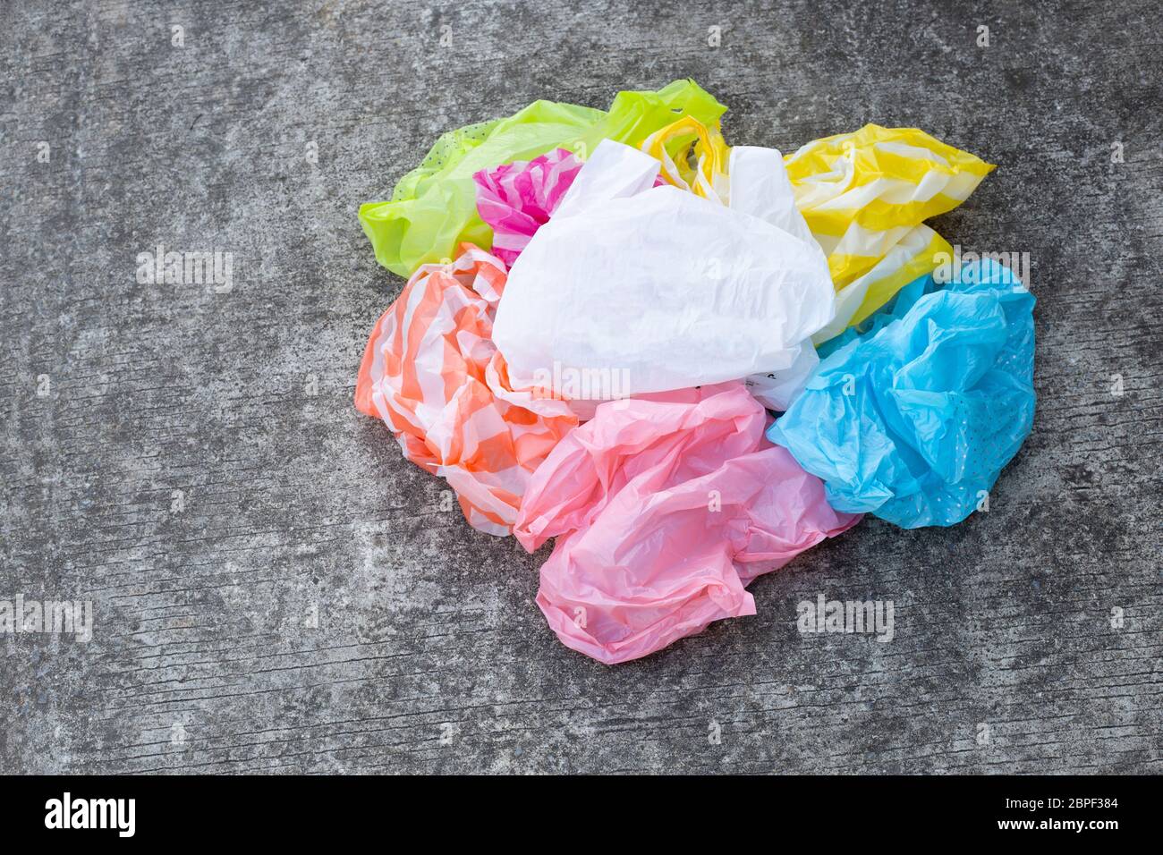 Colorful plastic bags on cement floor background. Stock Photo