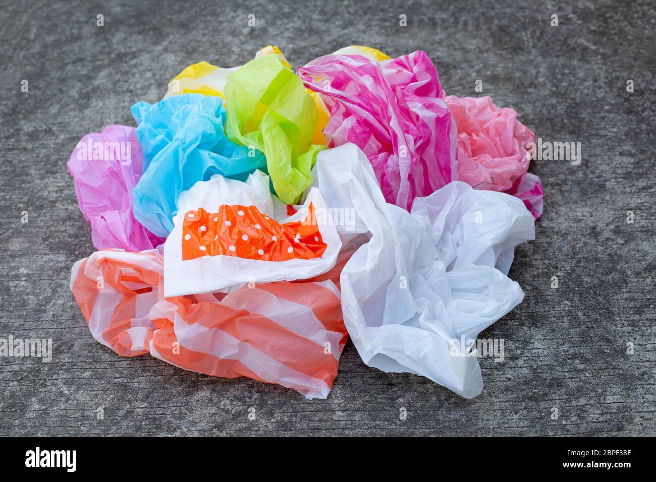 Colorful plastic bags on cement floor background. Stock Photo