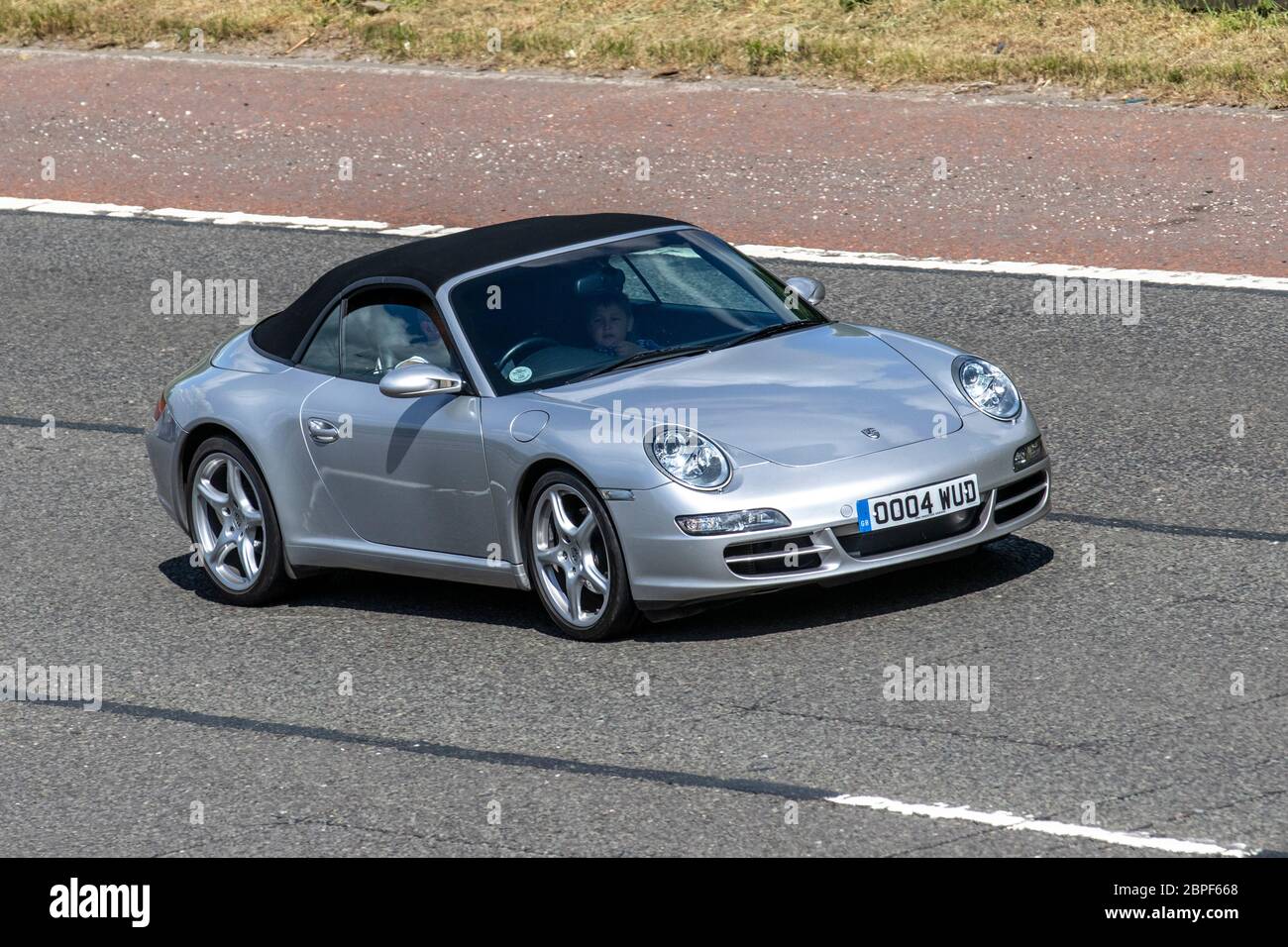 2001 silver Porsche 911 Carrera 2 convertible sportscars cars; Vehicular traffic moving vehicles, driving vehicle on UK roads, motors, motoring on the M6 motorway highway Stock Photo
