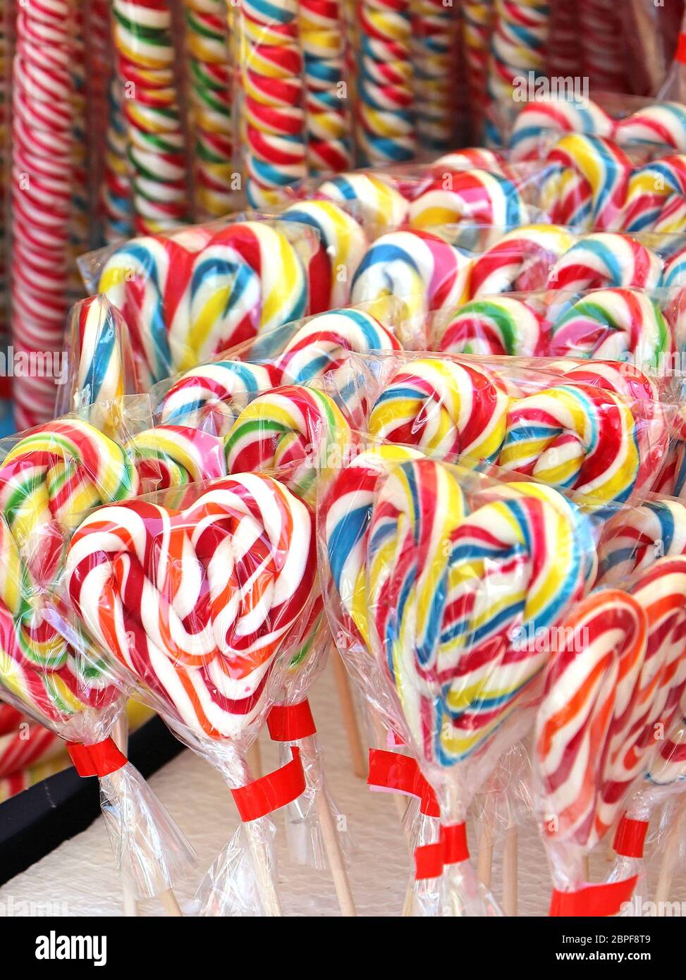 Colorful lollipops shaped as hearts inside cellophane wraps sold on
