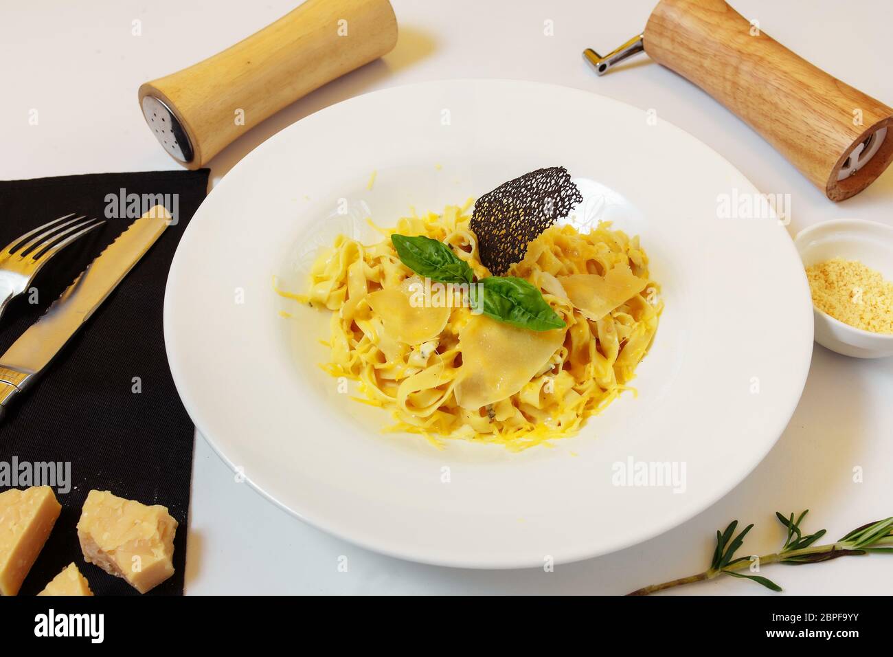 Pasta four cheeses. Homemade pasta, cream cheese sauce, Dor Blue, Cheddar, Parmesan, basil. Italian food. On a wooden background. Free space for text Stock Photo