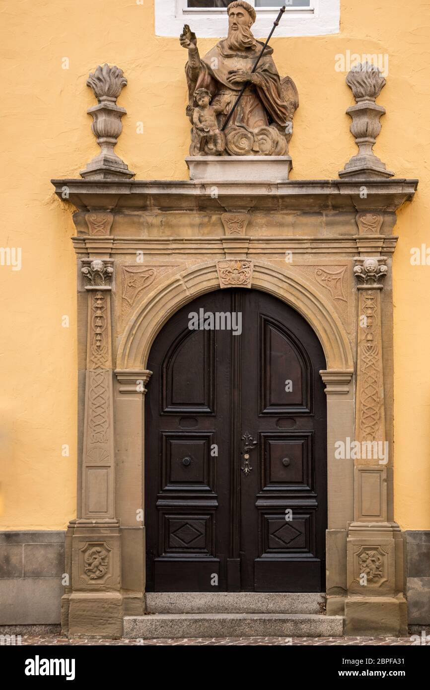 Old door of a historical building with statues and coats of arms made