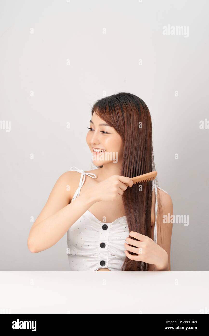 Young Asian woman combing her hair . Beauty concept Stock Photo