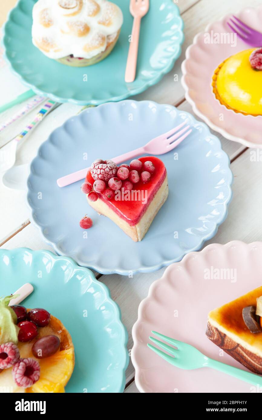 Delicious little cakes and pies on colorful plates Stock Photo