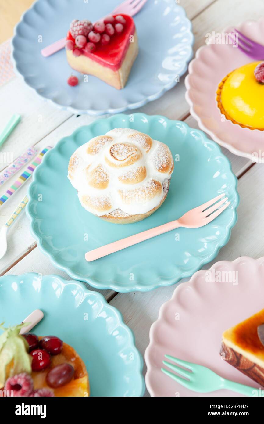 Delicious little cakes and pies on colorful plates Stock Photo