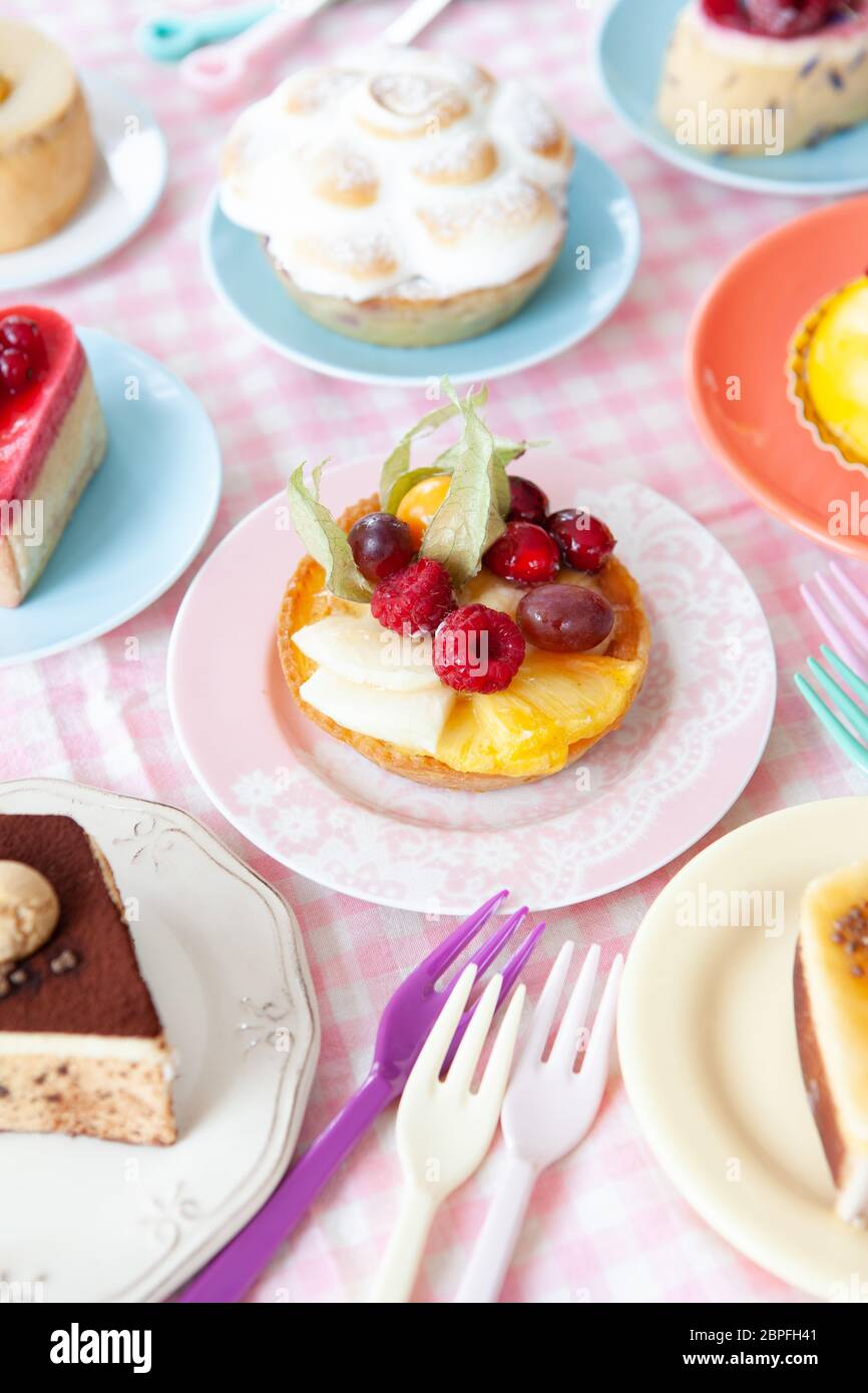 Delicious little cakes and pies on colorful plates Stock Photo