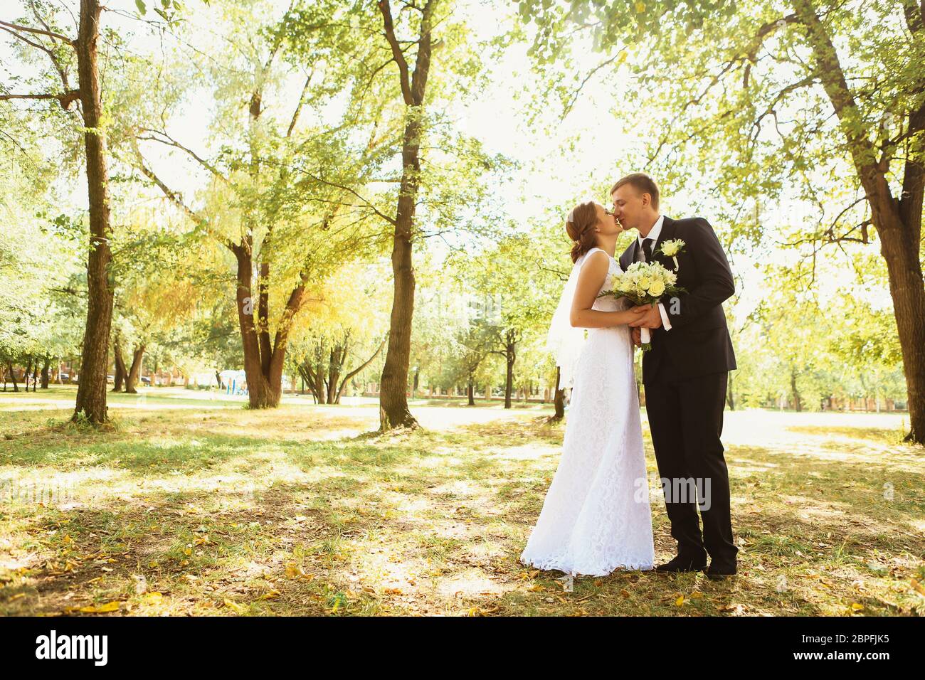couple bride and groom on a park background Stock Photo - Alamy