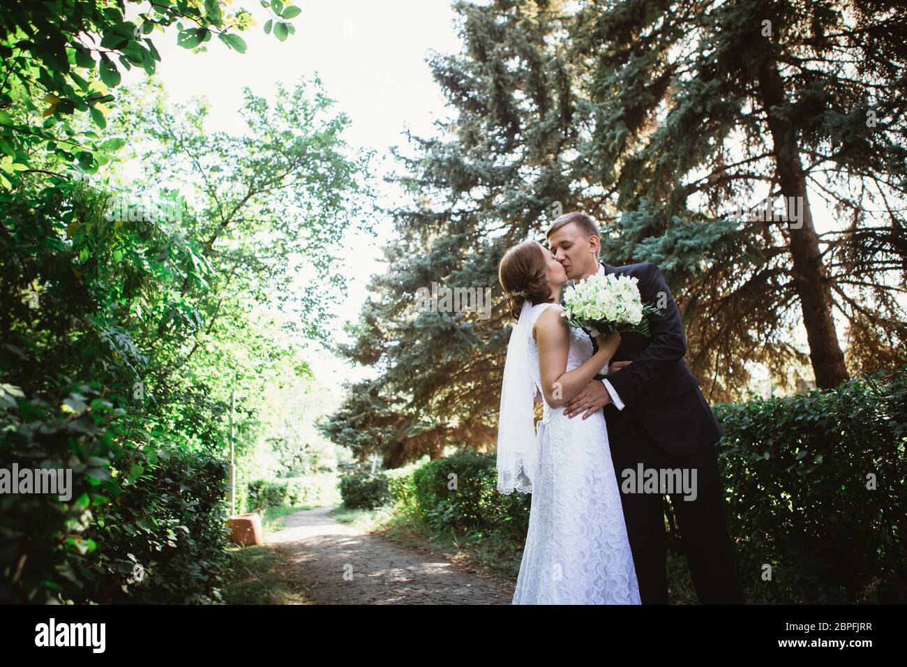 couple bride and groom on a park background Stock Photo - Alamy