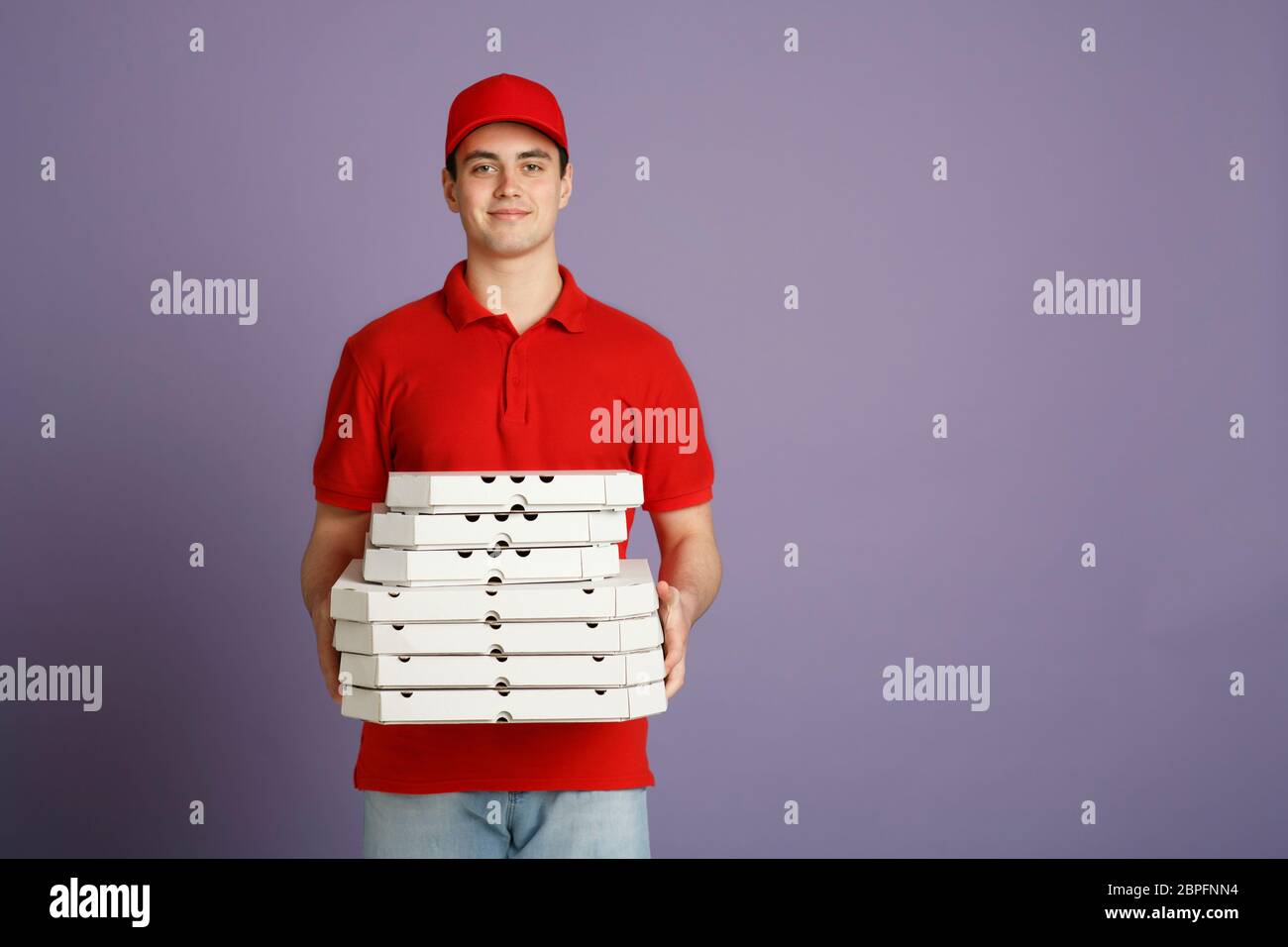 Party and large delivery of pizza at home. Courier holds many boxes Stock Photo