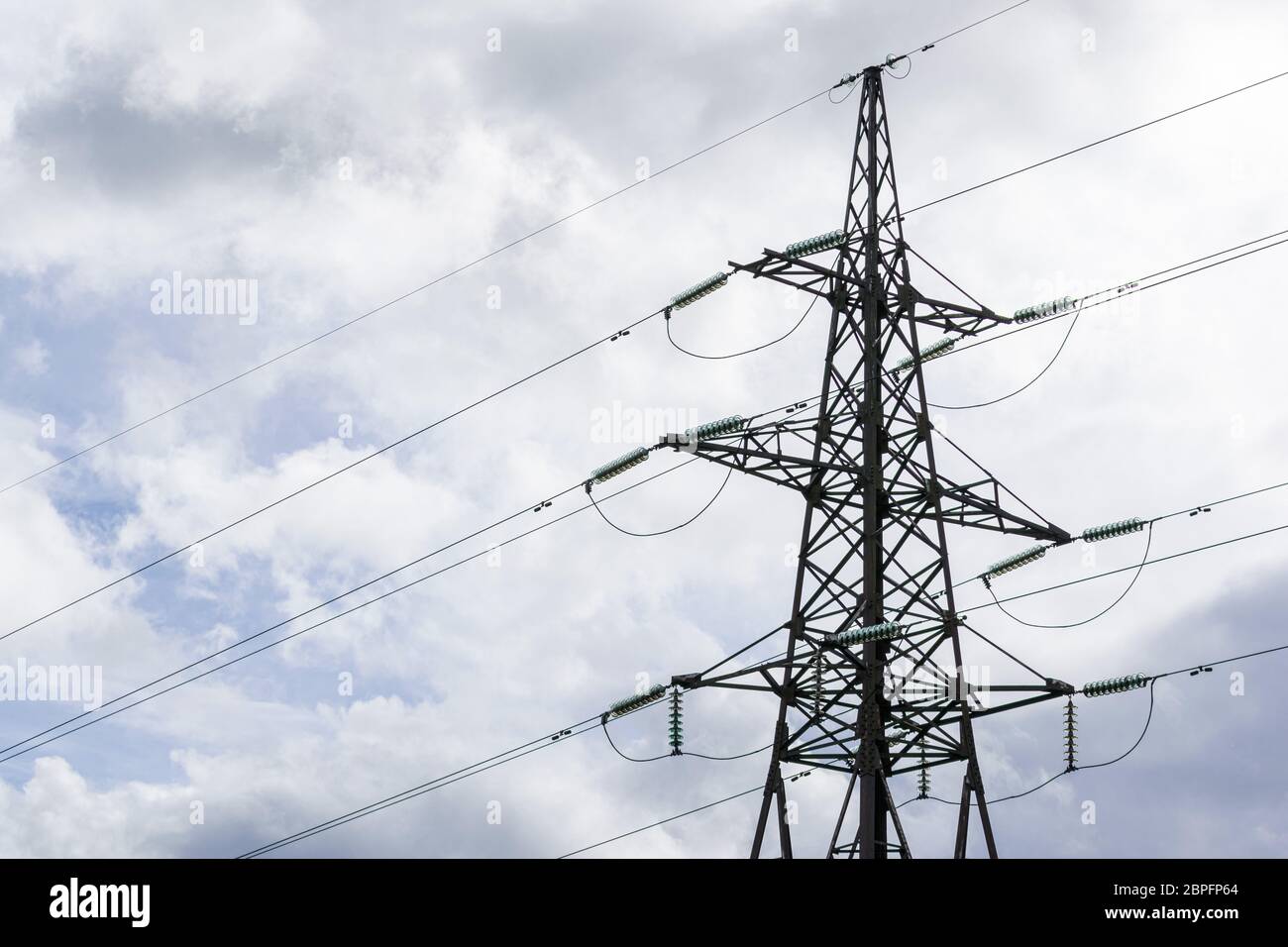A metal High voltage power transmission tower and lines against blue ...