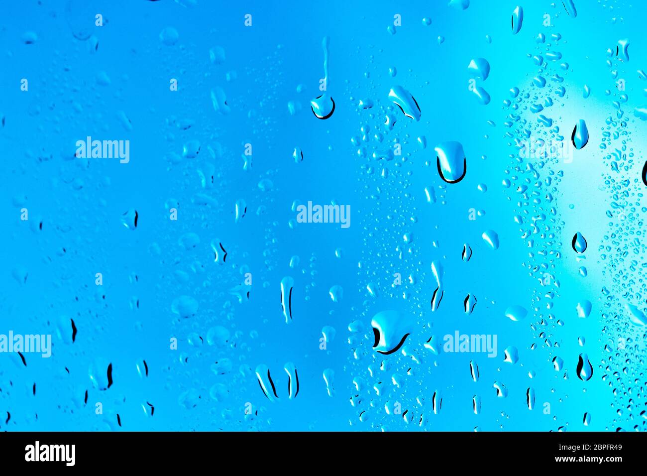 Drops on the glass rain blue background Stock Photo - Alamy