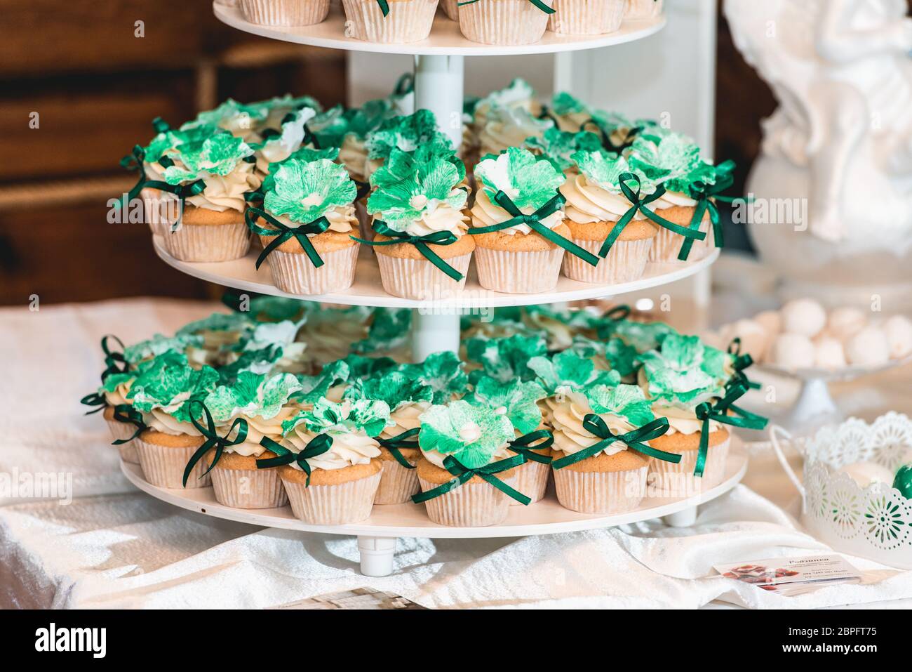 green style wedding candy bar on a white table. cupcakes decorated with a  green ribbon bow Stock Photo - Alamy, image size:1300x957