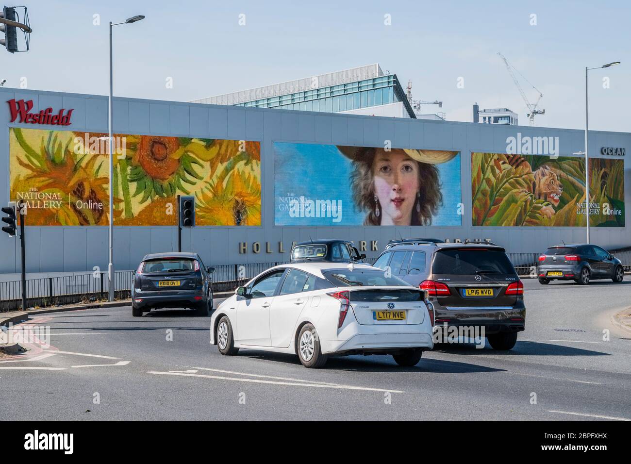 London, UK. 18th May 2020. The National Gallery has teamed up with digital outdoor screen provider, Ocean Outdoor, to bring orks of art out from behind the Gallery's temporarily closed doors. The digital sites are free for the next two weeks in order to display images of seven of the Gallery's most iconic paintings: Van Gogh's Sunflowers (1888) and A Wheatfield, with Cypresses (1889), Monet's The Water-Lily Pond (1899), van Eyck's The Arnolfini Portrait (1434), Seurat's Bathers at Asnières (1884), Vigée Le Brun's Self Portrait in a Straw Hat (1782) and Rousseau's Surprised! (1891). Stock Photo