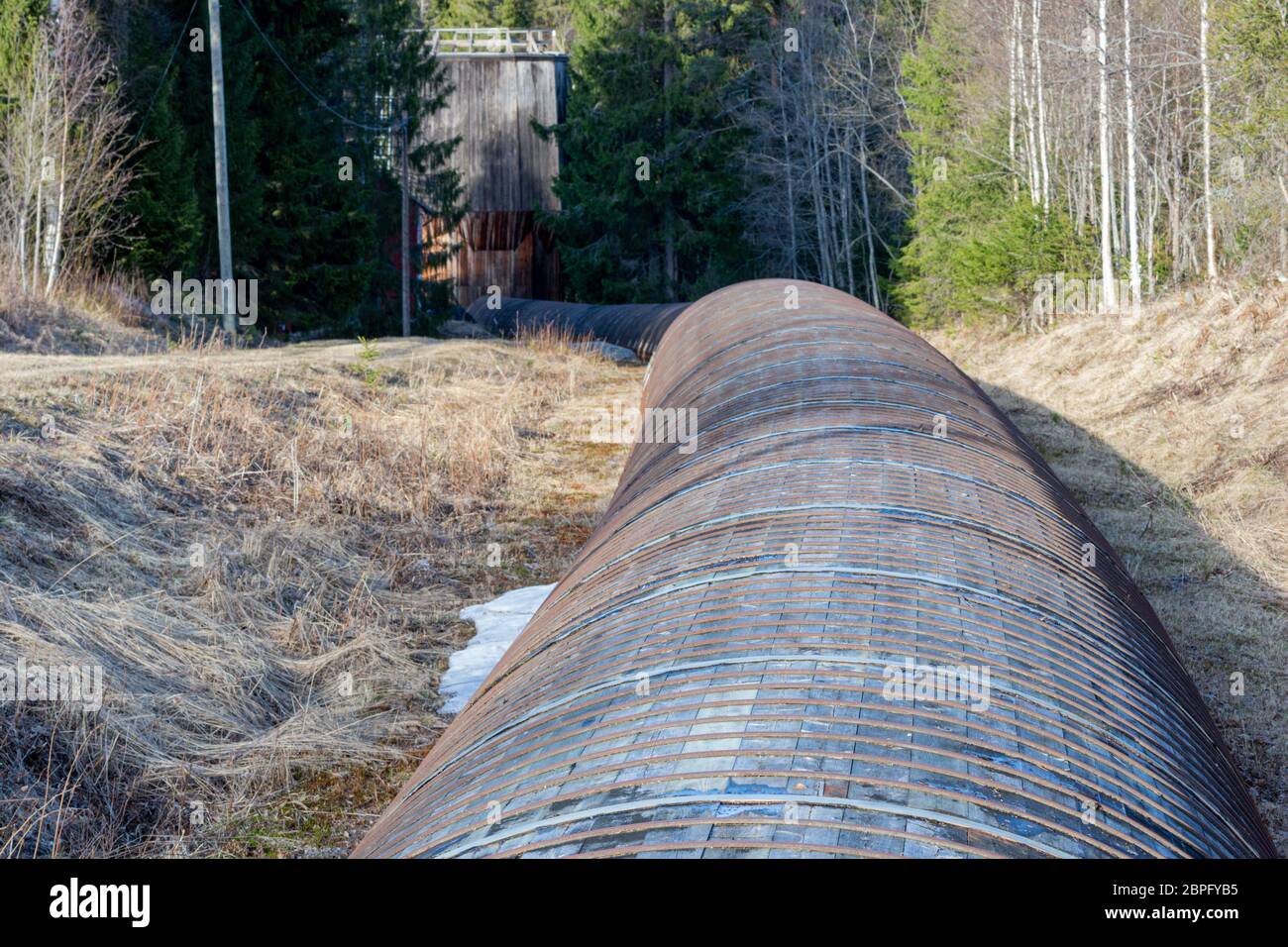 Tube of wood and steel leading the water from a dam to the generator room  in a little hydro power plant in the forest, picture from Mellansel  Vasterno Stock Photo - Alamy