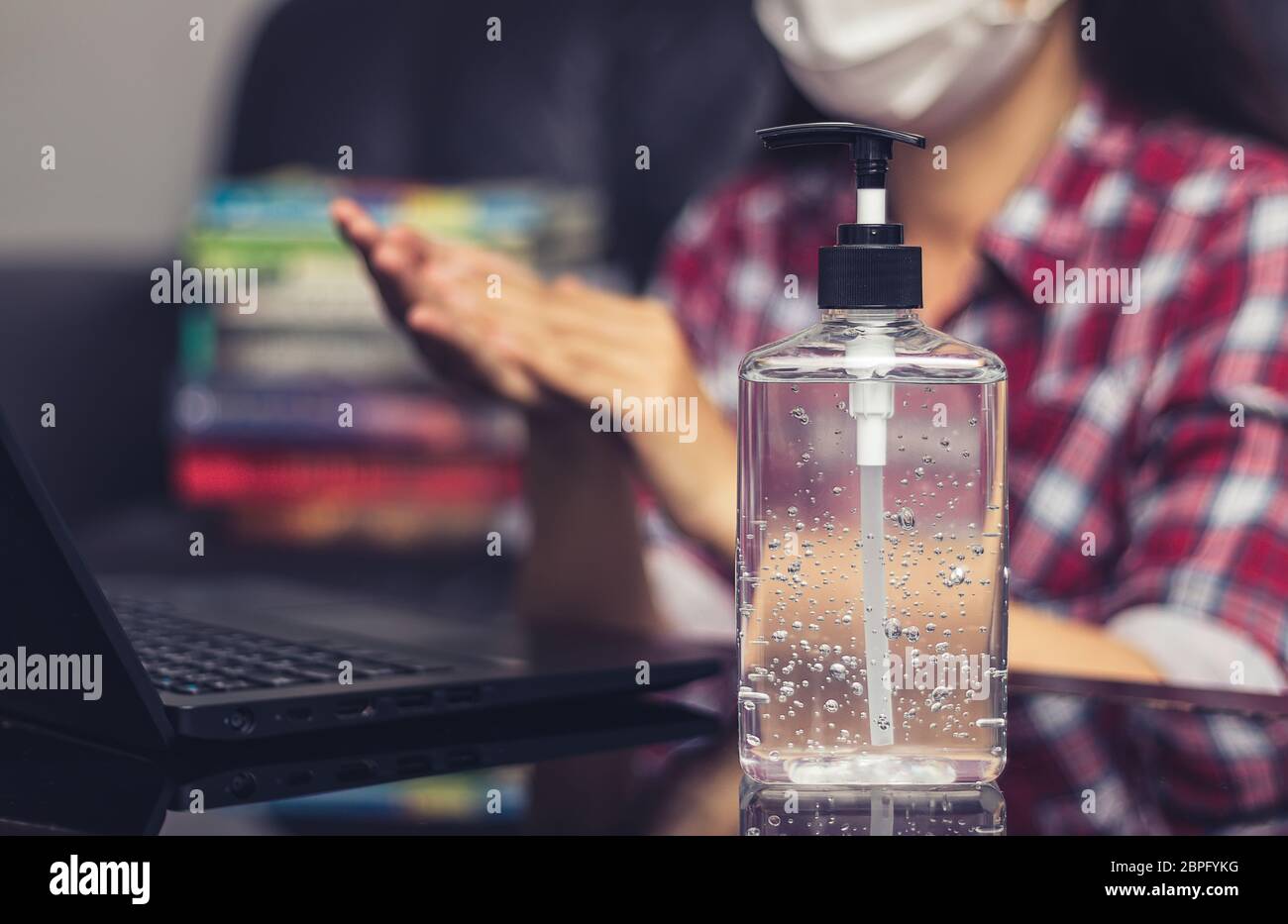 people washing hand by hand sanitizer alcohol gel for cleaning and disinfection, before typing on keyboard for working. prevention of germ spreading Stock Photo