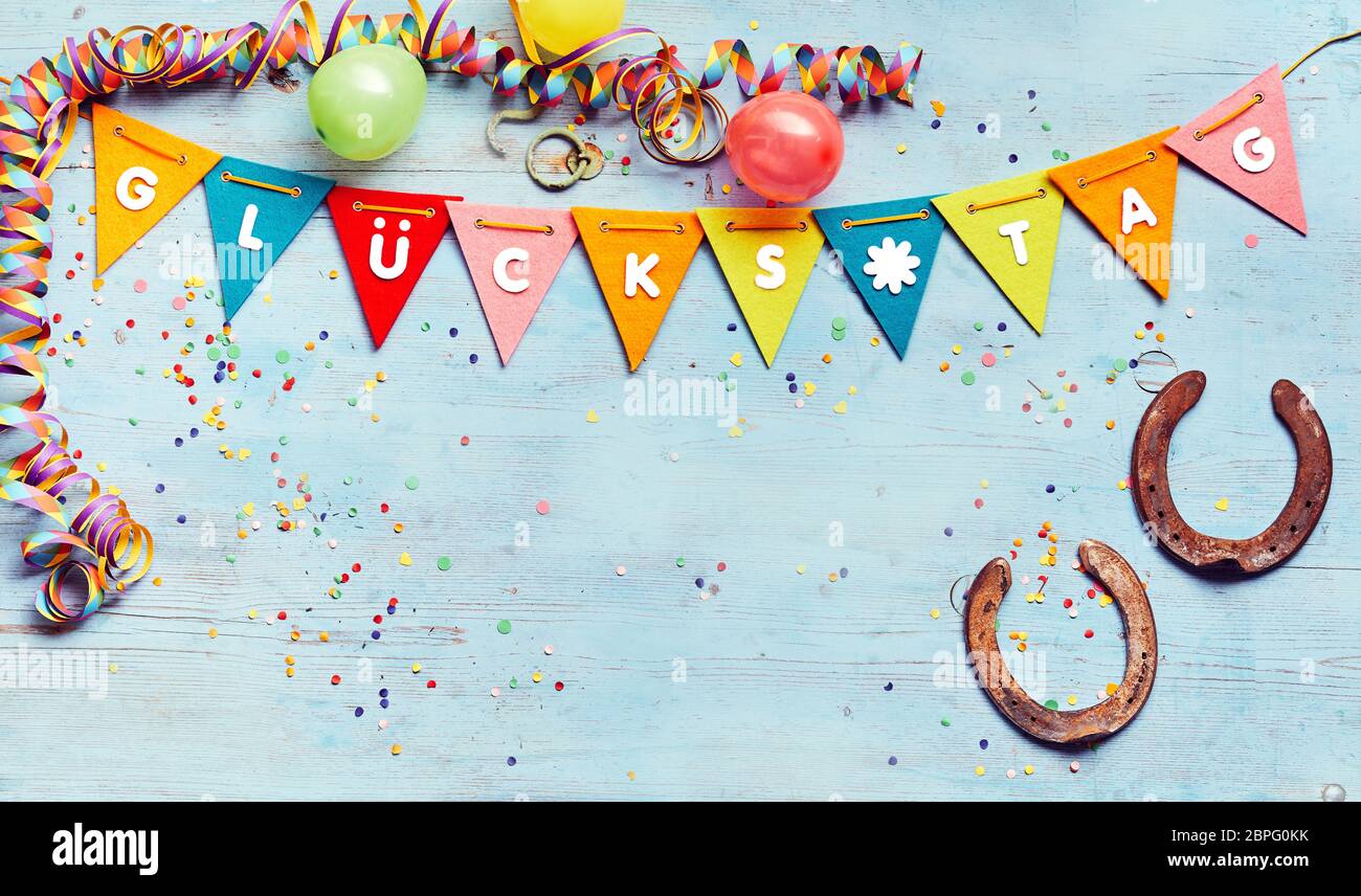 Glucks Tag or Good Luck background with copy space and a border of festive  colorful flags, streamers, balloons and two symbolic horseshoes Stock Photo  - Alamy