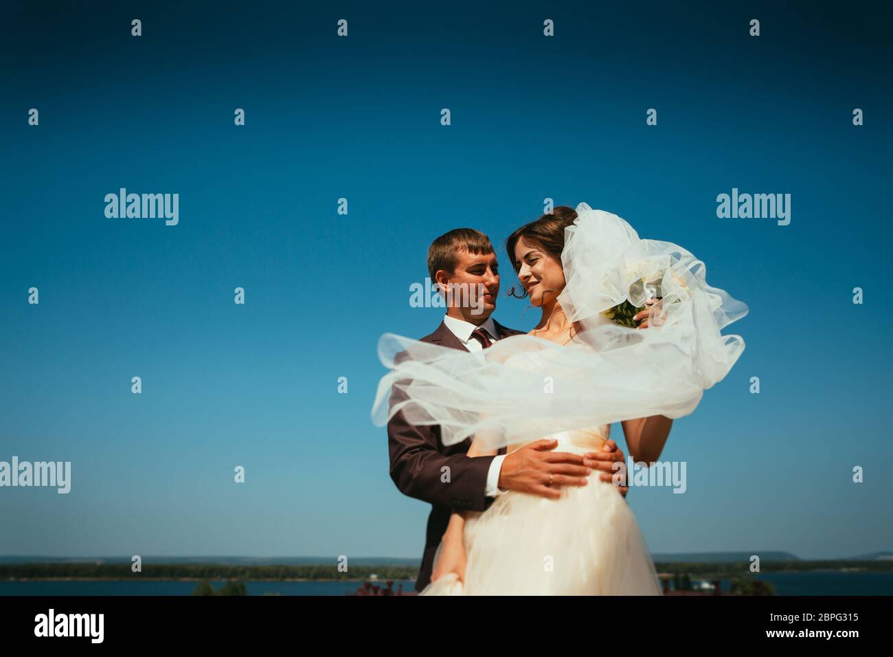 young bride and groom couple on the sky background Stock Photo - Alamy