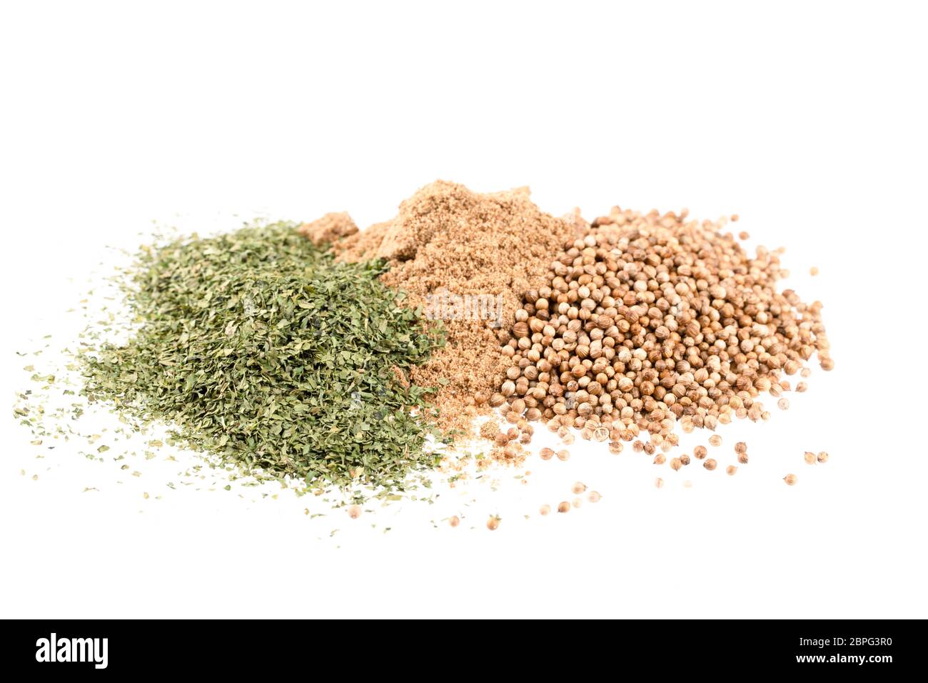 Pile of dried cilantro leaves, whole coriander seeds and coriander