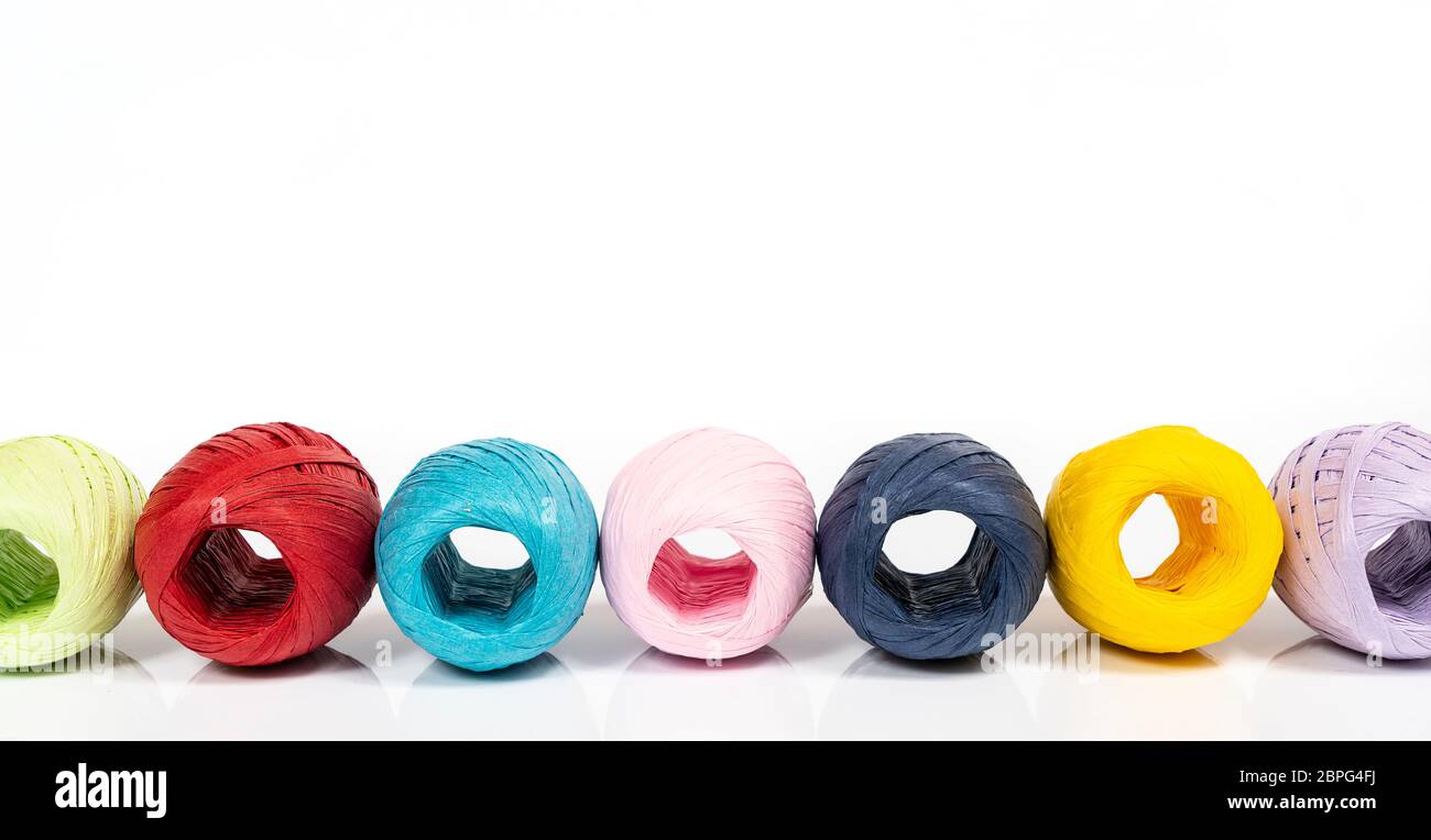 some balls of colored raffia on a white surface Stock Photo - Alamy
