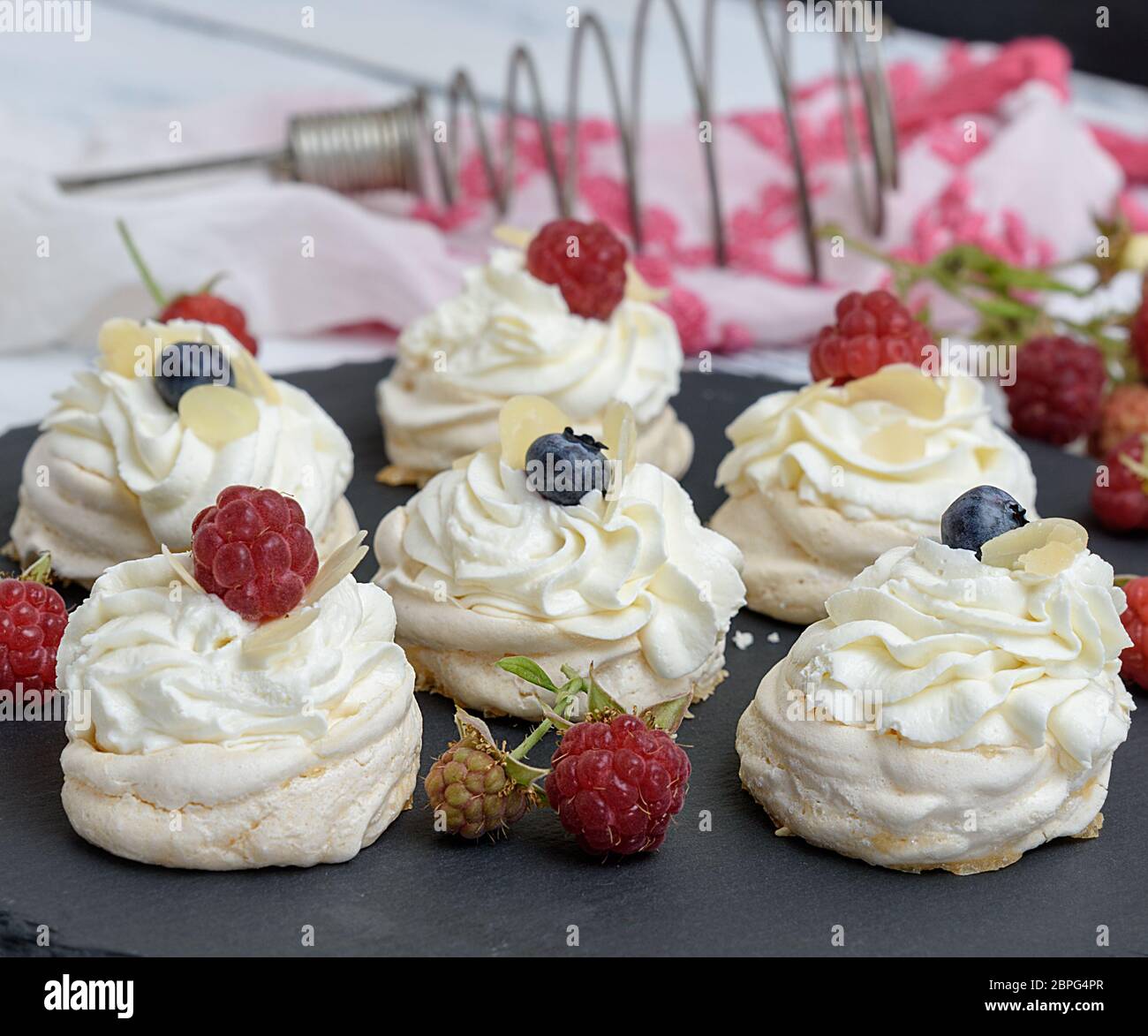 baked round meringues with whipped cream, dessert Pavlova Stock Photo