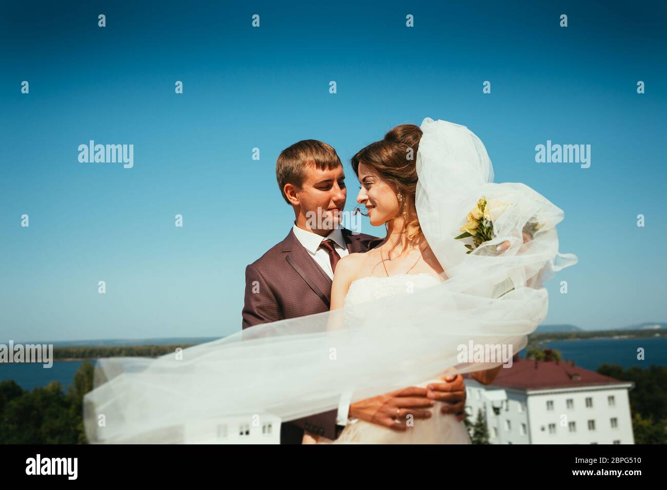 young bride and groom couple on the sky background Stock Photo - Alamy