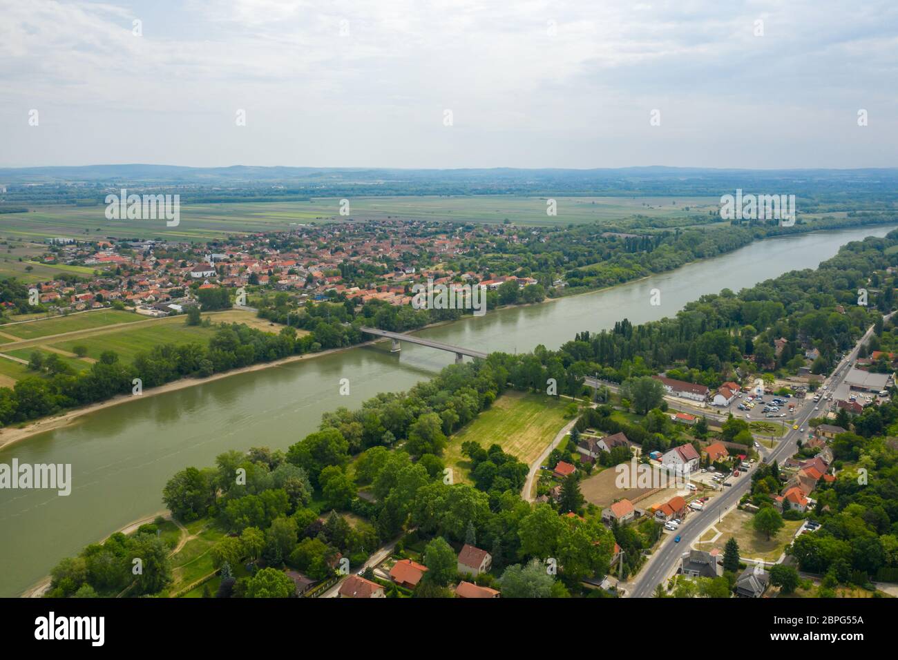 Establishing aerial view of Tahi and Tahitotfalu separated by the Danube river. Zoltan Tildy Bridge. Stock photo made on sunny summer day. Stock Photo