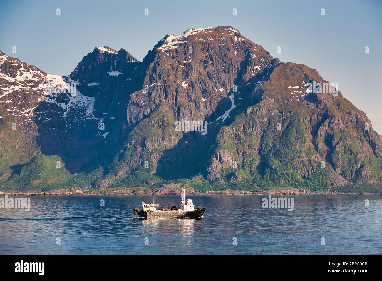 Fishing trawler sails past a mountain backdrop off the mid west coast of Norway, Scandinavia Stock Photo