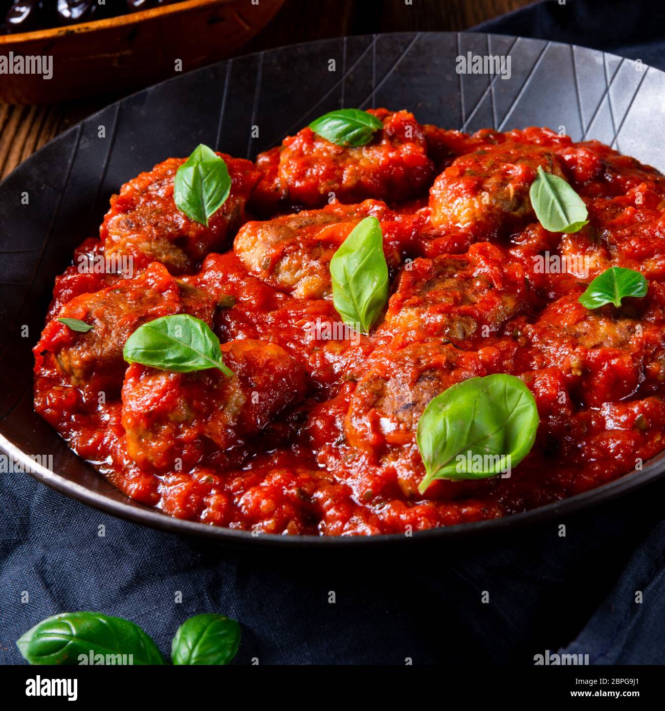 Baked mini meatballs in tomato sauce with basil Stock Photo Alamy