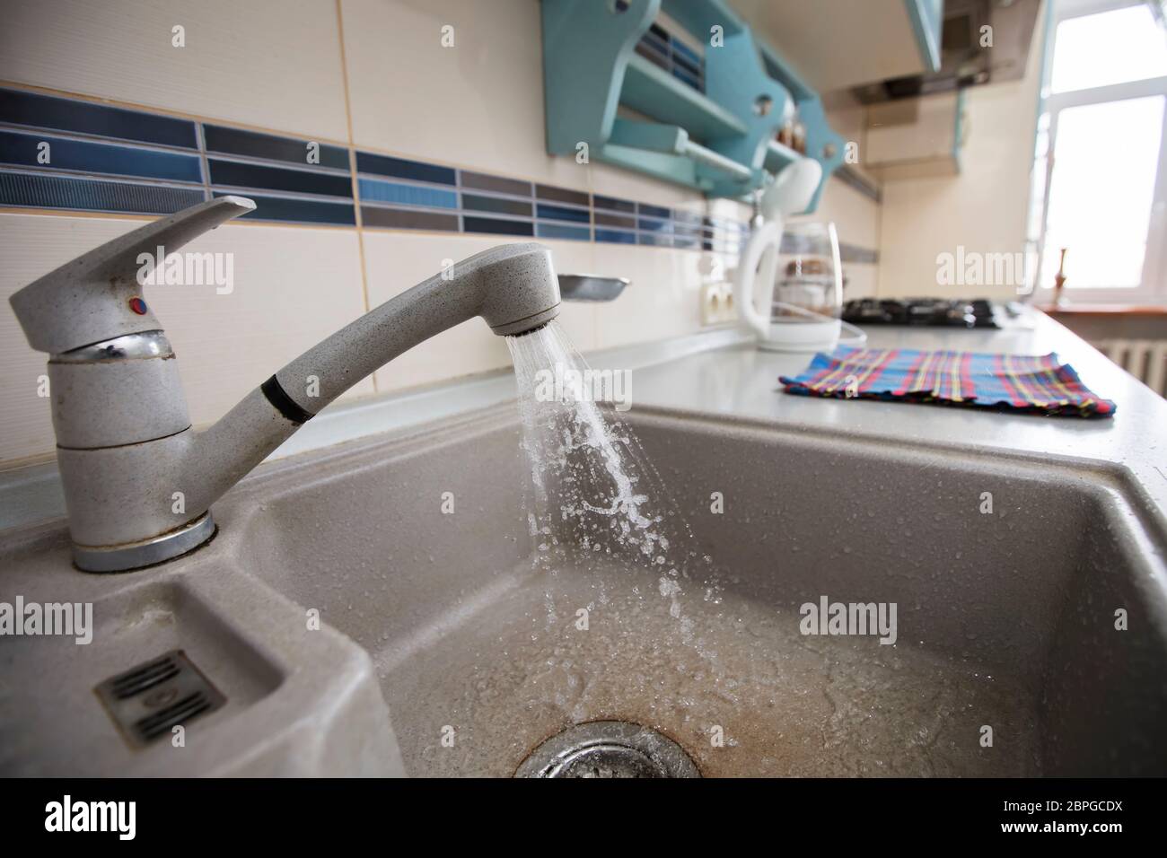 In the kitchen, water flows from a faucet into the sink Stock Photo Alamy