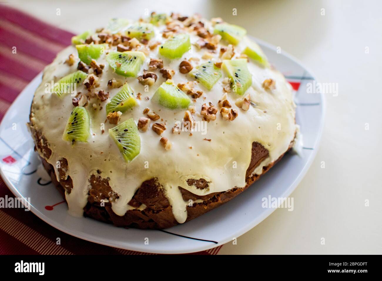 Plate with homemade kiwi cake with nuts. Easter cake. Stock Photo