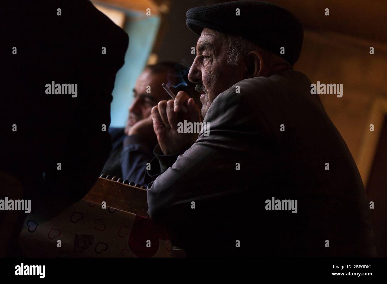 Men in the village of Lahic gather in the tea shop to meet and play dominos while drinking tea and smoking cigarettes in Lahic Azerbaijan. Stock Photo
