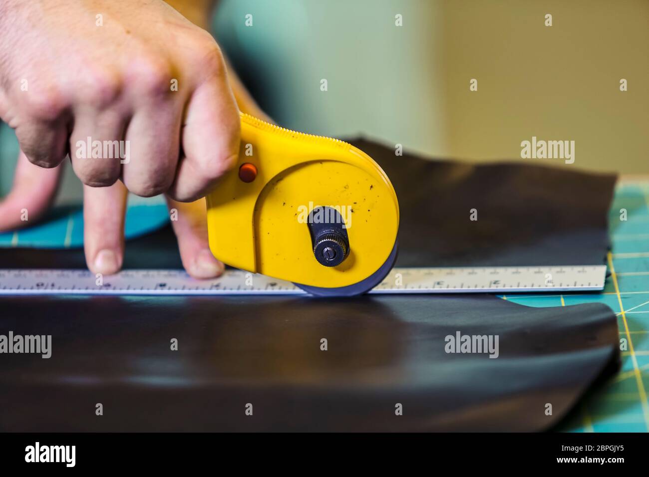 Cutting a piece of leather with a rotary cutter Stock Photo Alamy
